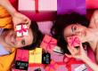 Two gen z on a colourful floor celebrating online shopping with gift boxes