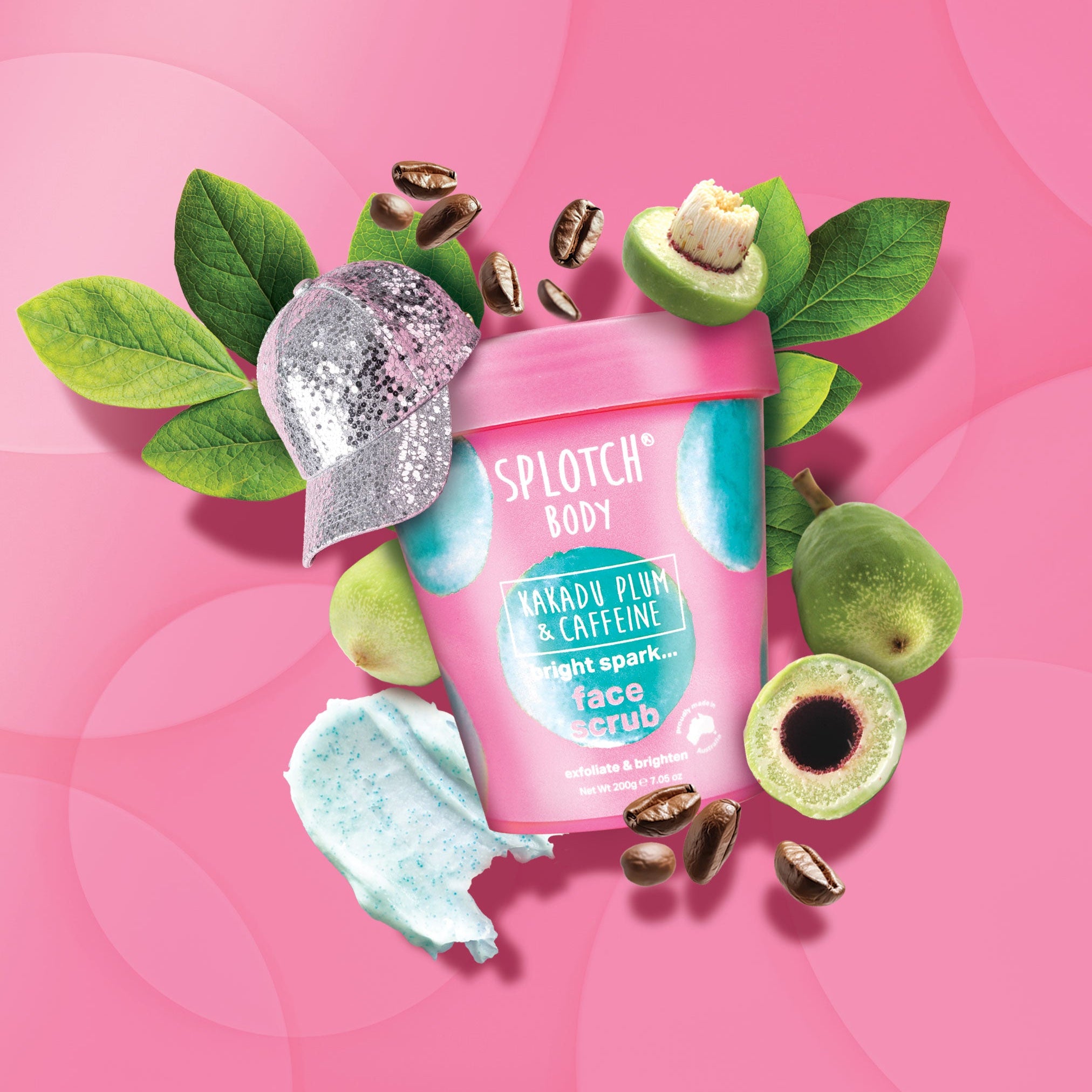 Splotch Body face scrub packaging with green leaves and coffee beans on a pink background
