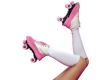 A set of legs is shown wearing white knee-high socks and pink-and-white roller skates with pink wheels.